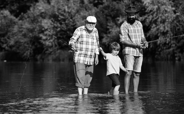 Pescando garotinho pescando em um lago com seu pai e avô, feliz avô e avô