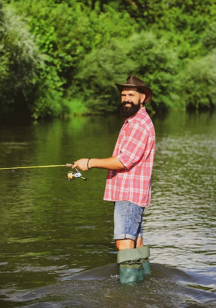 Pescando um belo pescador pescando em um rio com uma vara de pescar homem pescador pega um peixe peixe a