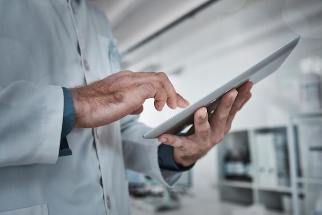 Pesquisa científica e mãos de homem com tablet em pesquisa de laboratório na internet e dados de exames médicos Inovação farmacêutica em saúde e cientista com tecnologia e verificação de resultados online