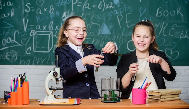 Pesquisa de química Aula de biologia Meninas no laboratório da escola Educação em química Experimentos científicos no laboratório de química Pequeno cientista trabalha com microscópio O que parece ser um problema