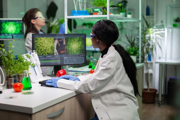 Pesquisador médico afro-americano digitando perícia médica em bioquímica