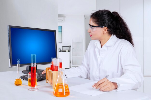 Pesquisadora feminina usando um computador em laboratório