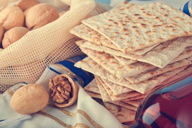 Pessach-Feier-Konzept Matza rot koscher und Walnuss Traditionelles Ritual jüdisches Brot Matza Kippah und Tallit auf altem Holzhintergrund Pessach-Essen Pessach jüdischer Feiertag Getöntes Bild