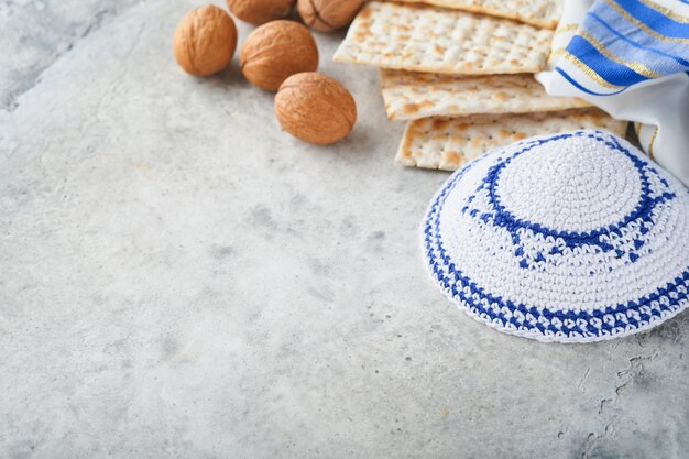 Pessach-Feier-Konzept Matzah rot koscher und Walnuss Traditionelles Ritual jüdisches Brot Matzah Kippah und Tallit auf altem Betonhintergrund Pessach-Essen Jüdischer Feiertag Pessach