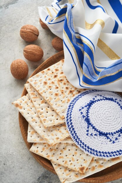 Pessach-Feier-Konzept Matzah rot koscher und Walnuss Traditionelles Ritual jüdisches Brot Matzah Kippah und Tallit auf altem Betonhintergrund Pessach-Essen Jüdischer Feiertag Pessach