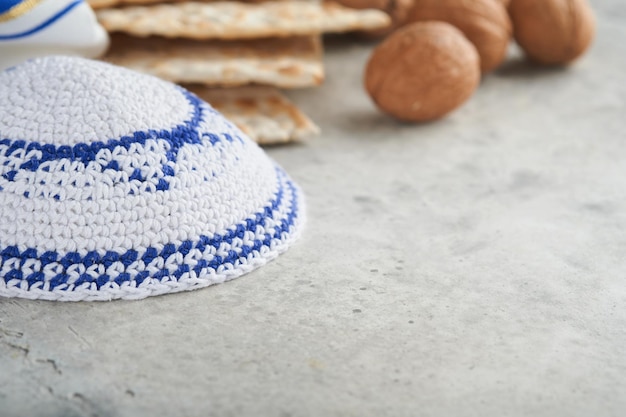 Pessach-Feier-Konzept Matzah rot koscher und Walnuss Traditionelles Ritual jüdisches Brot Matzah Kippah und Tallit auf altem Betonhintergrund Pessach-Essen Jüdischer Feiertag Pessach