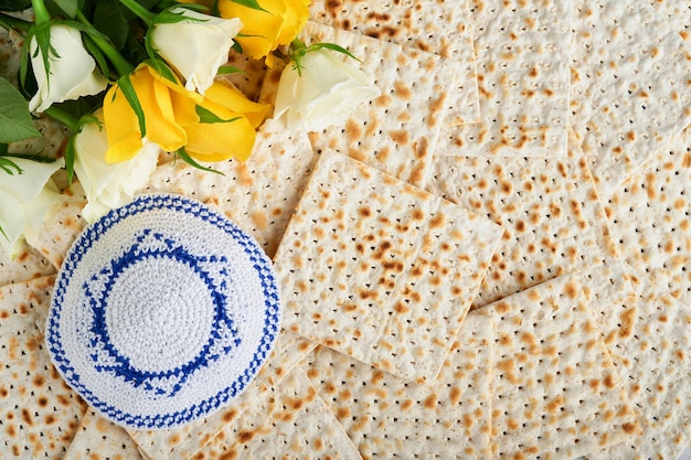 Foto pessach-feier-konzept matzah rote koschere weiße und gelbe rosen und walnuss traditionelles ritual jüdisches brot matzah kippah und tallit auf altem hintergrund pessach-essen jüdischer feiertag pessach