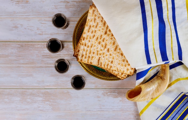 Pessach Matzoh jüdisches Feiertagsbrot und vier Gläser Wein über Tisch