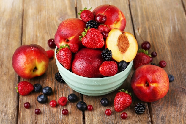 Pêssegos e frutas na tigela na mesa closeup