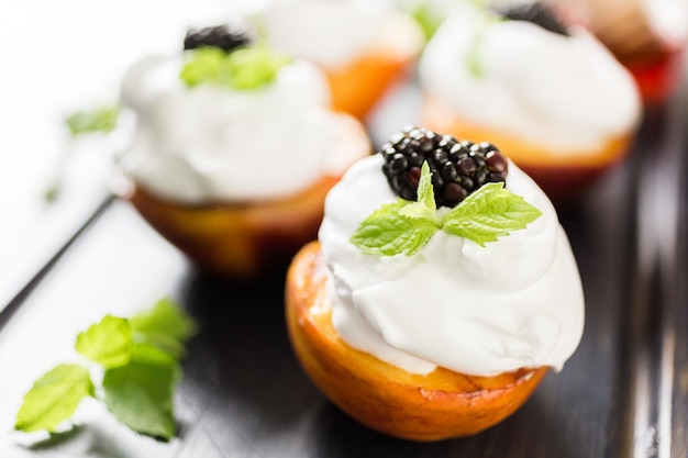 Pêssegos orgânicos grelhados com chantilly e guarnecidos com hortelã fresca.