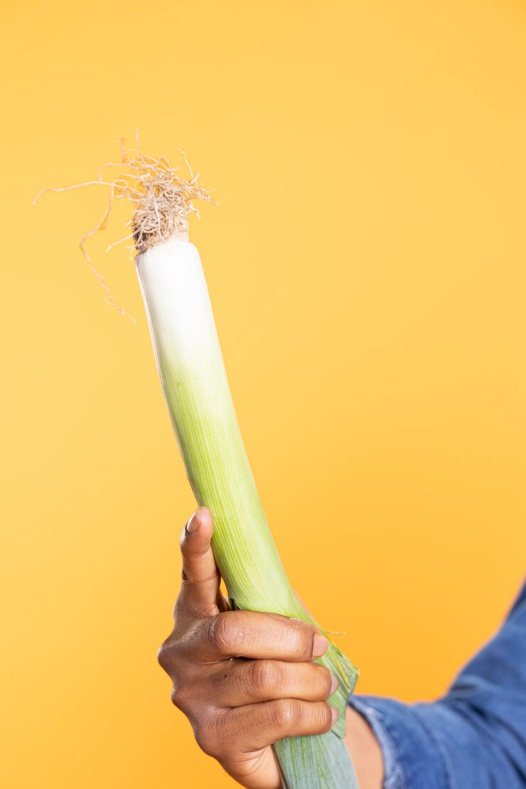 Foto pessoa afro-americana apresentando uma planta de alho-poró deliciosa e crua
