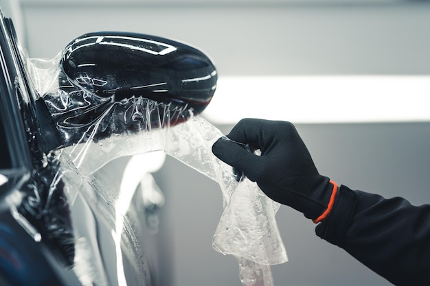 Foto pessoa aplicando filme protetor ppf para tinta que protege a pintura do carro contra arranhões e cascalho