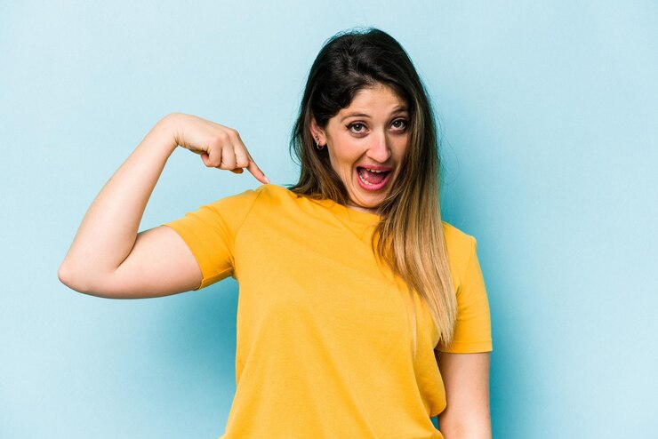Foto pessoa apontando com a mão para um espaço de cópia de camisa orgulhoso e confiante