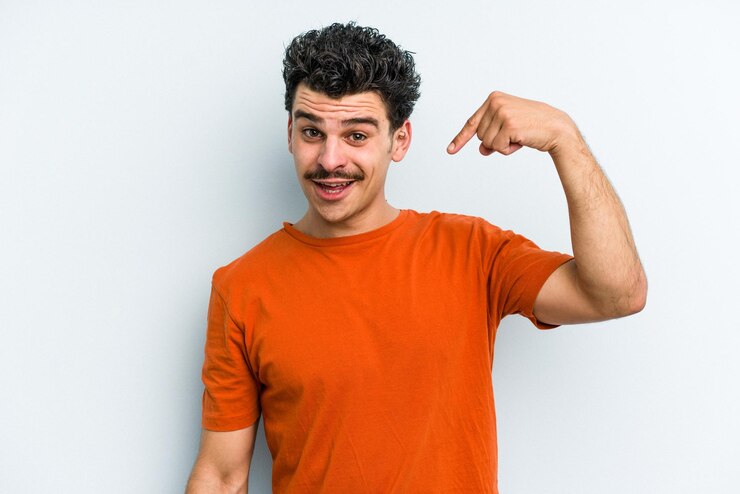 Foto pessoa apontando com a mão para um espaço de cópia de camisa orgulhoso e confiante