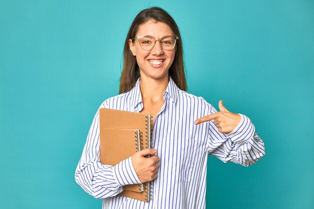 Pessoa apontando com a mão para um espaço de cópia de camisa orgulhoso e confiante