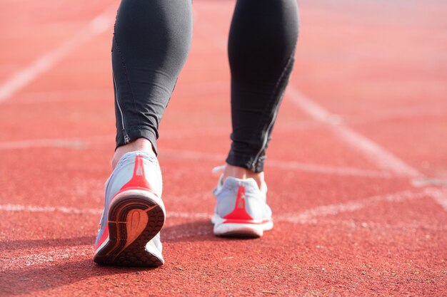 Pessoa atlética na pista de corrida, preparando-se para começar a correr