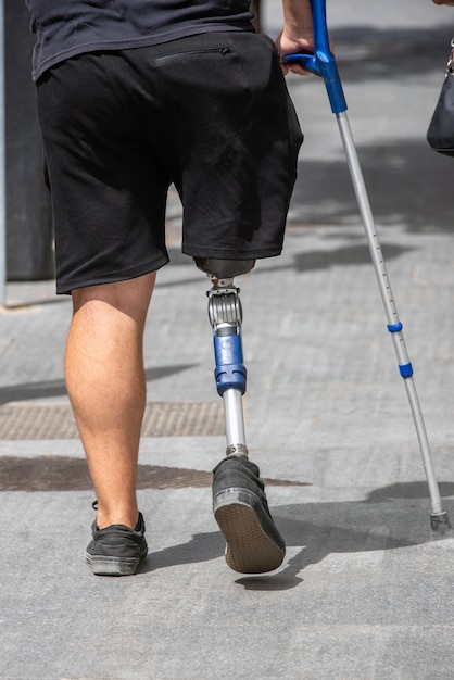 Foto pessoa caminhando na rua com uma perna prótese