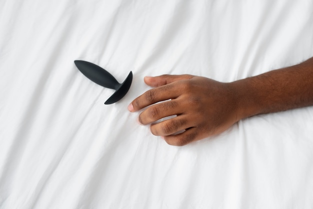 Foto pessoa com brinquedo sexual na cama