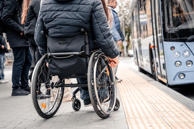 Pessoa com deficiência física à espera de transporte municipal com rampa acessível