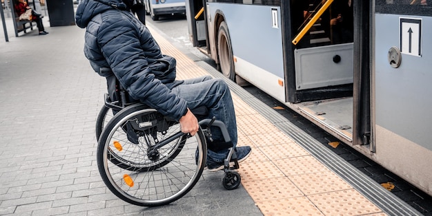 Pessoa com deficiência física entra no transporte público com rampa acessível