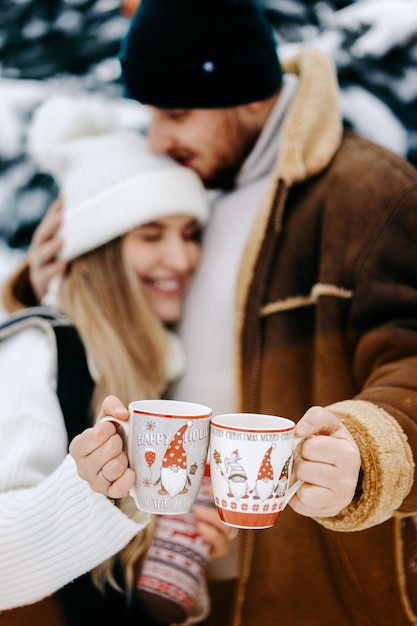 pessoa com uma xícara de ti, um casal curtindo o inverno