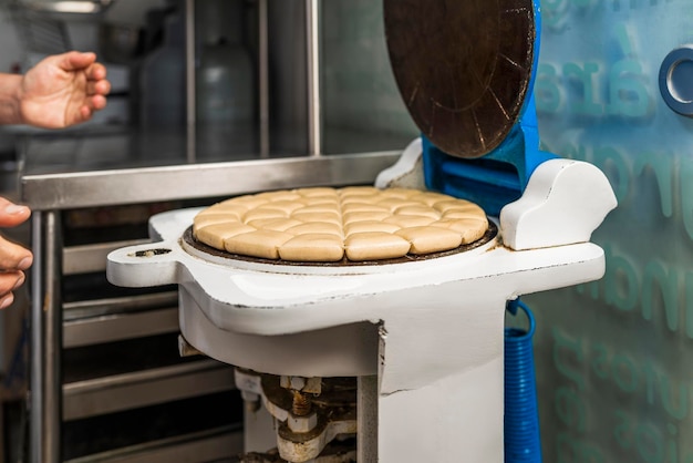 Pessoa cortando pão em diferentes unidades em uma padaria artesanal