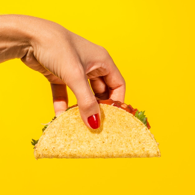 Foto pessoa de close-up com taco e fundo amarelo