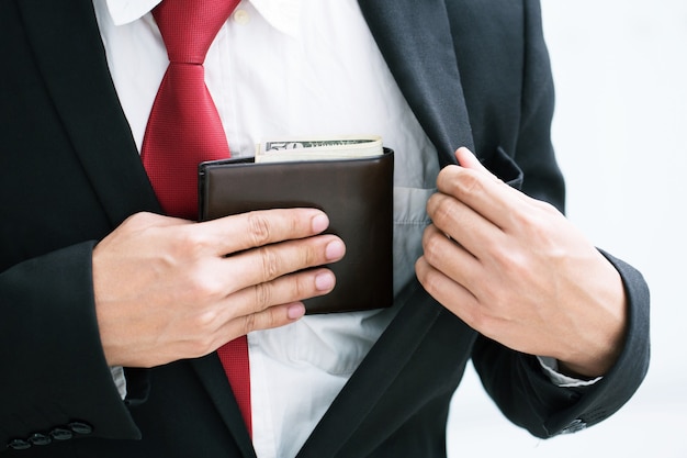 Foto pessoa de empresário segurando uma carteira nas mãos de um homem que tira dinheiro do bolso.