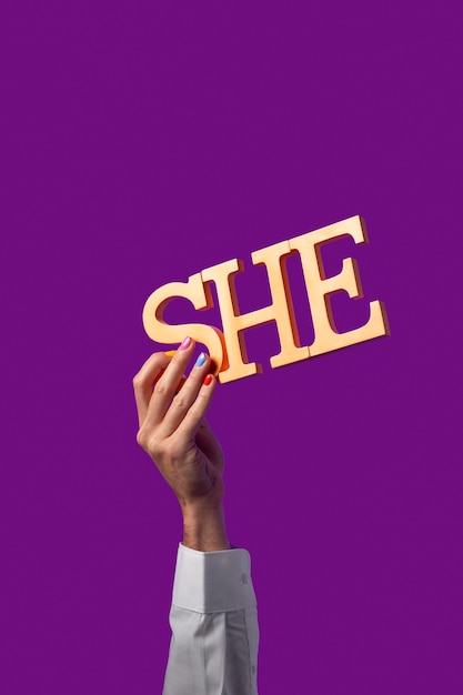 Foto pessoa de gênero fluido segurando um pronome isolado em roxo