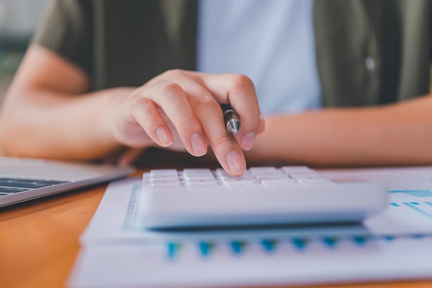 Foto pessoa de negócios sentada em uma mesa em um escritório usando a calculadora para trabalhar análise e planejamento de conceito de negócios