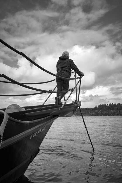 Foto pessoa em um barco olhando para o mar