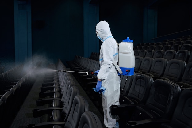 Pessoa especial fazendo desinfecção em sala de cinema.