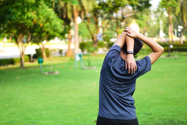 Pessoa esticando o corpo para aquecer no parque para uma boa saúde, perda de peso, boa forma