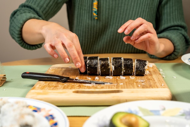 Pessoa fazendo deliciosos sushis caseiros na cozinha