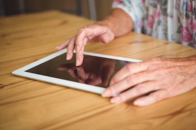 Pessoa idosa tocando um tablet digital