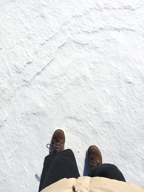 Foto pessoa irreconhecível a caminhar sobre o gelo