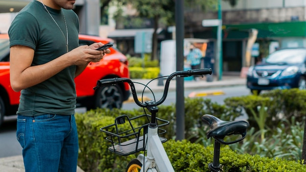 Pessoa irreconhecível usando bicicleta por aplicativo de telefone.