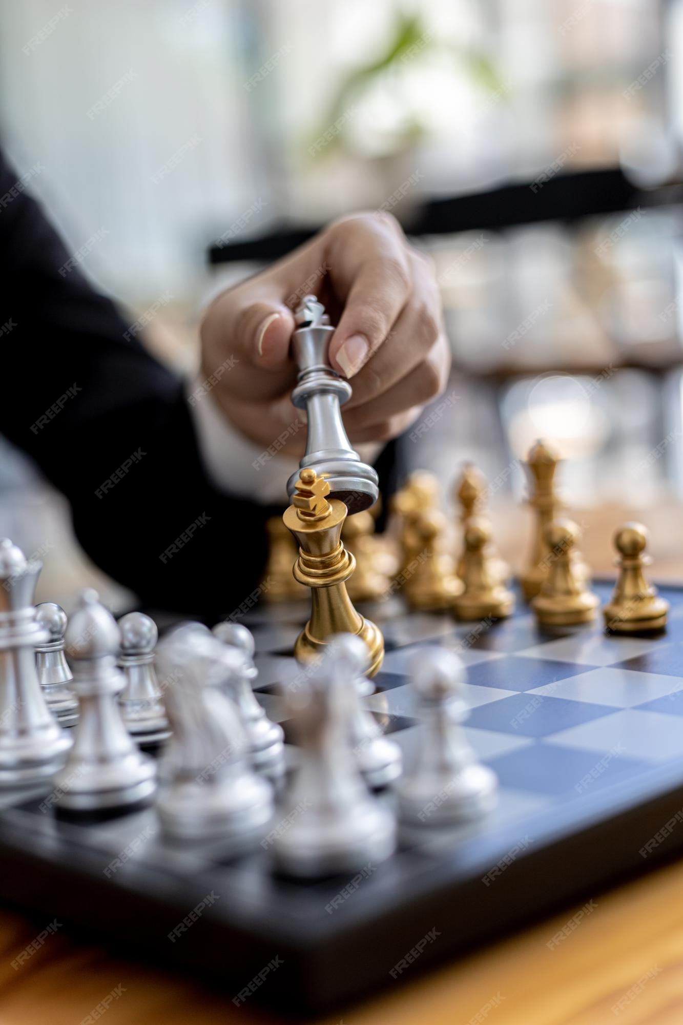 Pessoa jogando jogo de tabuleiro de xadrez, imagem de conceito de homem de  negócios segurando peças de xadrez como competição de negócios e  gerenciamento de risco, planejando estratégias de negócios para derrotar