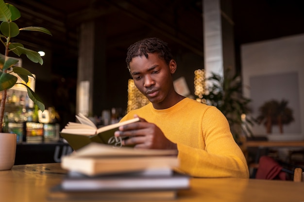 Foto pessoa lendo um livro em um café