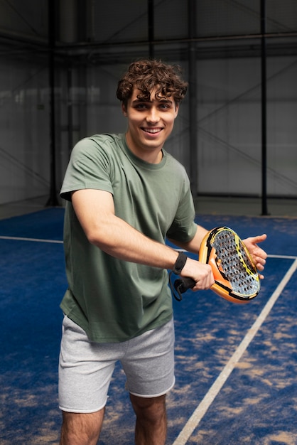 Pessoa se preparando para jogar padel dentro