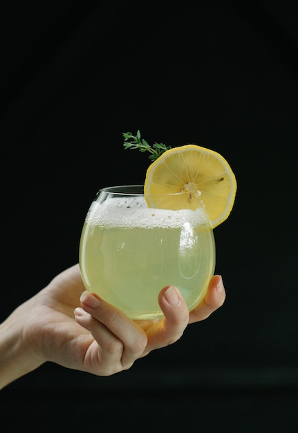 Foto pessoa segurando um copo transparente com suco de limão