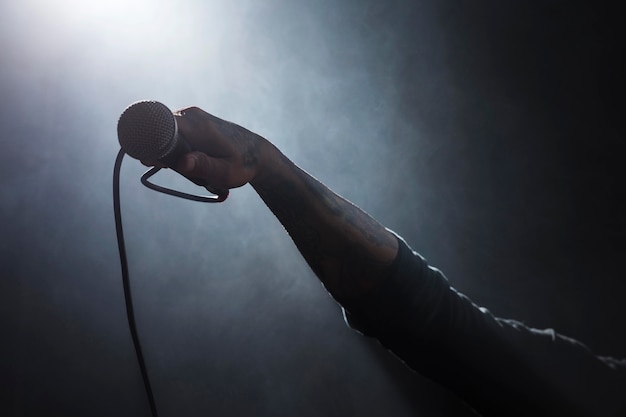 Foto pessoa segurando um microfone no palco