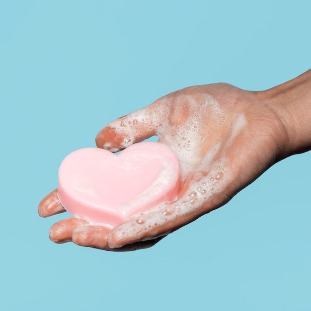 Foto pessoa segurando um sabonete em forma de coração