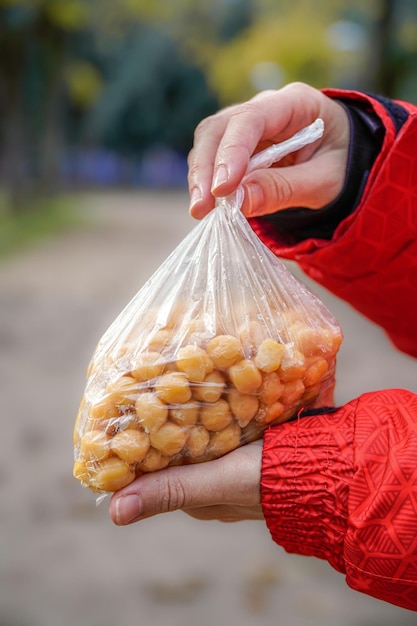 Pessoa segurando um saco de grão-de-bico leguminosas na mão na rua