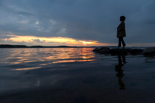 Foto pessoa triste e contemplativa perto do lago