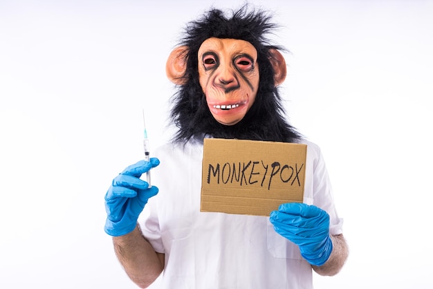 Pessoa vestida com um macaco com uma máscara com um terno de enfermeira médica com um sinal que diz 39MONKEYPOX39 e uma seringa em um fundo branco Epidemia de vírus pandêmico Nigéria e conceito de varíola