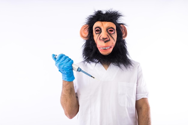 Pessoa vestida com uma máscara de macaco com uma roupa de enfermeira médica segurando uma pipeta de laboratório em um fundo branco monkeypox epidemia de vírus pandêmico nigéria e varíola