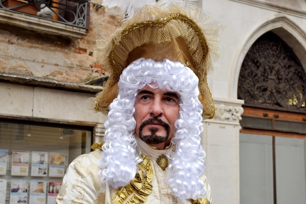 Pessoa vestida para o Carnaval de Veneza com roupas douradas