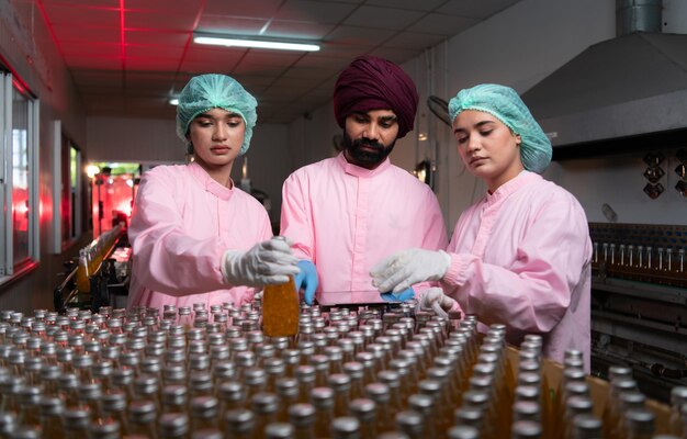 Foto pessoal de controlo da qualidade do produto na linha de produção de sumo de frutas realizar controlos da qualidade do producto