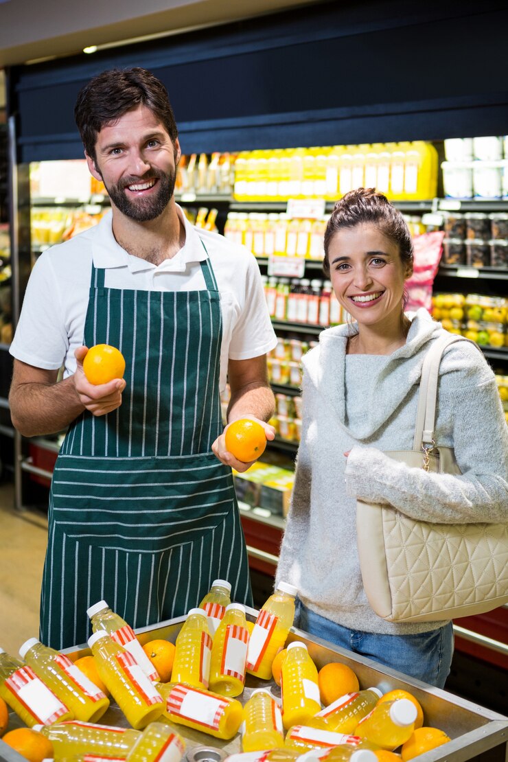 Foto pessoal masculino sorridente, ajudando uma mulher com compras de supermercado
